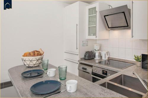 a kitchen with a counter with plates and a bowl of bread at Ferienanlage Bansin Seepferdchen 6 in Bansin