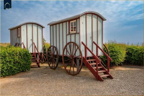two playhouses with largeokedoked wheels sitting next to some bushes at Ferienanlage Bansin Seepferdchen 6 in Bansin