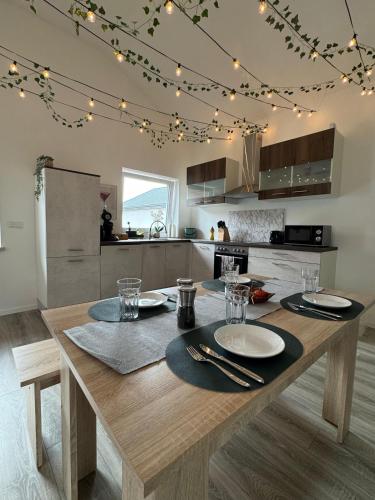 a kitchen with a wooden table with plates and glasses at Waldzauber - Moderne Ferienwohnung im Grünen in Elpenrod