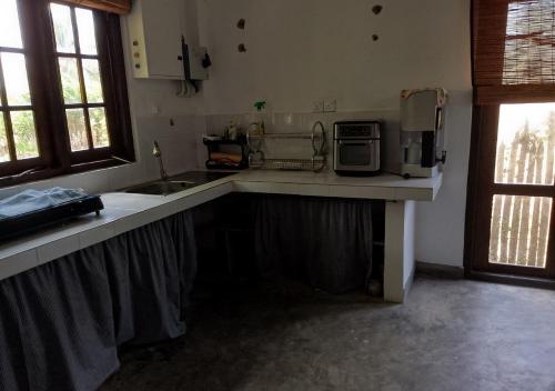 a kitchen with a counter with a microwave and a sink at Genge Lake Resort - Kalpitiya in Pallivasalturai