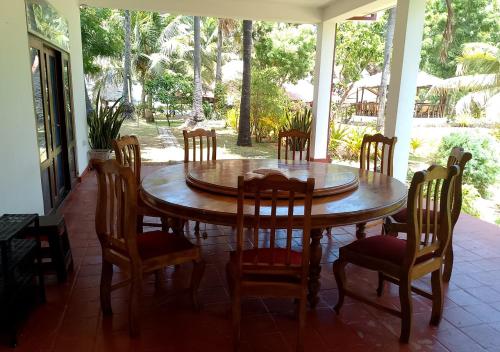 a wooden table and chairs on a porch at Genge Lake Resort - Kalpitiya in Pallivasalturai