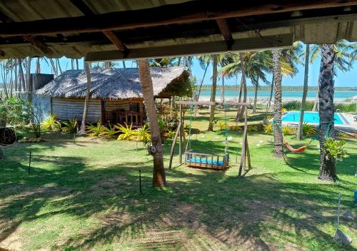a resort with a hammock and a hut with palm trees at Genge Lake Resort - Kalpitiya in Pallivasalturai