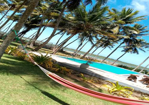 a hammock sitting on the grass next to a pool at Genge Lake Resort - Kalpitiya in Pallivasalturai