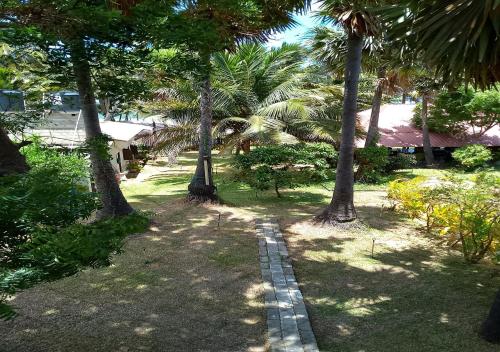 a garden with palm trees and a brick path at Genge Lake Resort - Kalpitiya in Pallivasalturai