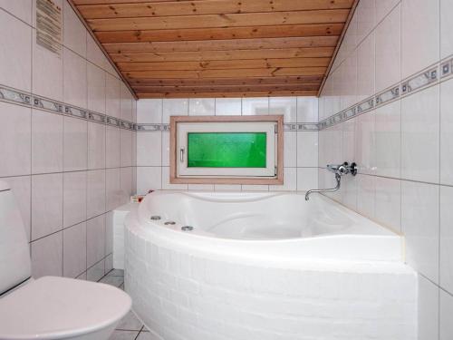 a white bathroom with a tub and a toilet at Secluded Retreat by Lyngbo Heath - By Traum Ferienwohnungen in Henne Strand
