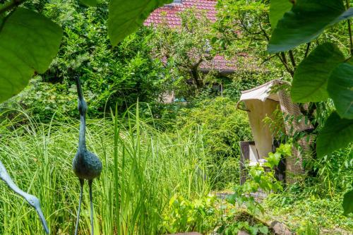 a garden with a peacock statue in the grass at Ferienwohnungen Behling am Schufutsberg in Liepe