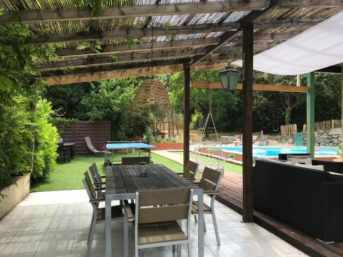 a patio with a table and chairs and a pool at Maison belle-vie in Corconne