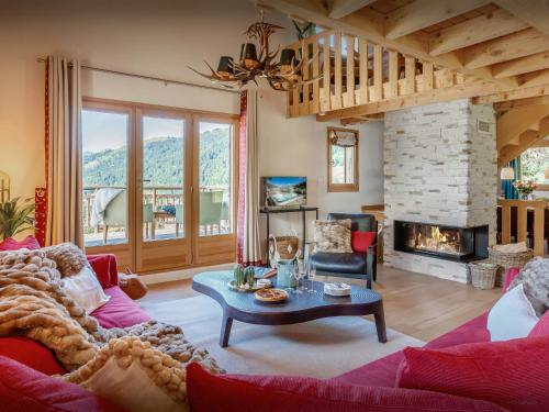 a living room with a couch and a fireplace at Chalet Joux Verte - OVO Network in Les Gets