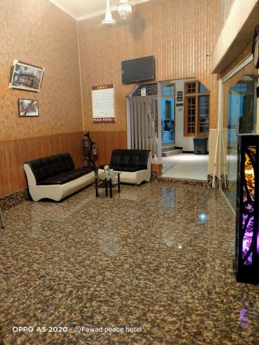a living room with two couches and a television at Peace Hotel Fizagat, Swat in Mingora