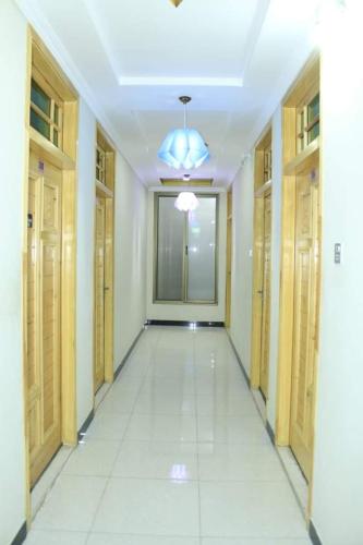 an empty hallway with wooden doors and a ceiling at Peace Hotel Fizagat, Swat in Mingora