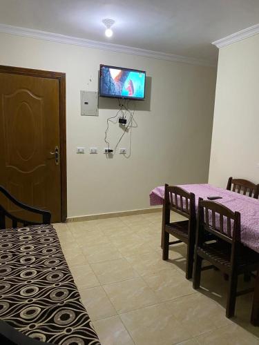 a room with a table and a tv on the wall at Blubay VIP in Marsa Matruh