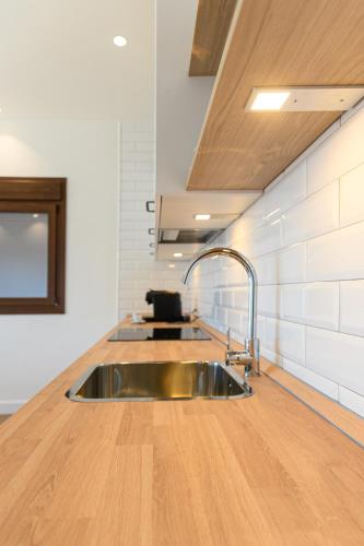 a kitchen with a sink and a wooden counter top at Hacienda Los Manchones in Doña Mencía