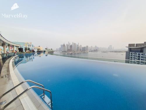 a large pool of blue water on top of a building at MarvelStay-Infinity Pool-Beachfront-The Palm in Dubai