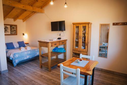 ビージャ・ペウエニアにあるSUOMIのベッドとテーブルのあるリビングルームと寝室