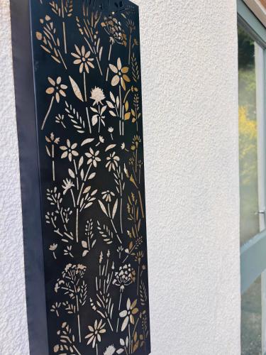 a black and gold curtain with flowers on a window at Dolmans Retreat in Lytchett Matravers