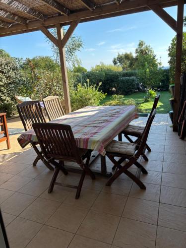 une table et des chaises assises sur une terrasse dans l'établissement Maison à Lumio Marine de Sant Ambroggio en Balagne, Haute Corse / Holiday House Corsica, à Lumio