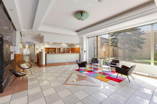 a living room with chairs and a table at Hotel Montago- Dein großes Zimmer mit hervorragender Infrastruktur in Neu Isenburg
