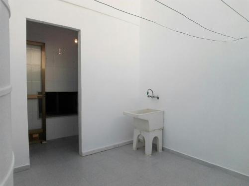 Un baño con un lavabo en una pared blanca. en Casa Paqui, en Carboneras