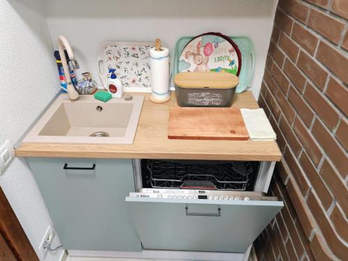 a kitchen counter with a sink next to a brick wall at CASA DE SUB MAGURA in Simeria