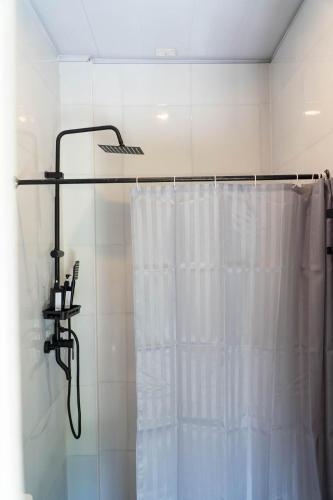 a shower with a white shower curtain in a bathroom at FOREVER SIARGAO in General Luna