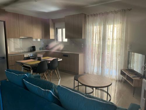 a living room with a blue couch and a kitchen at Gastouni Urban stay in Gastoúni