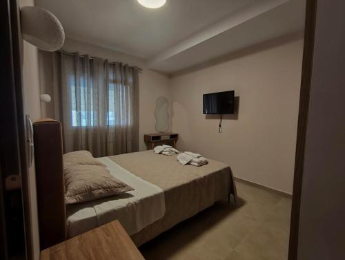 a small bedroom with a bed and a television at Gastouni Urban stay in Gastoúni