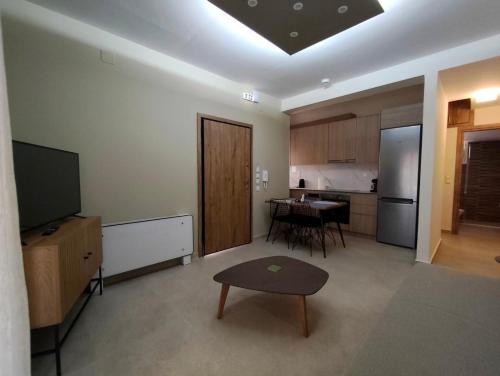a living room with a television and a kitchen at Gastouni Urban stay in Gastoúni