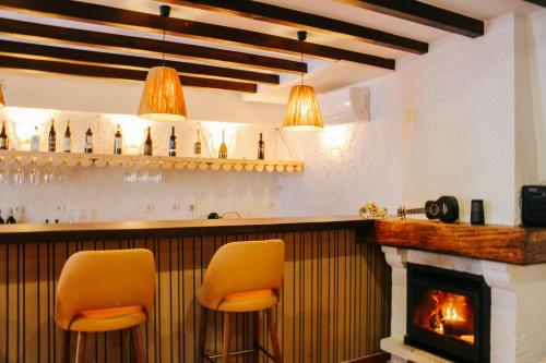 a bar with two chairs and a fireplace at Penedo Escape Nature in Colares