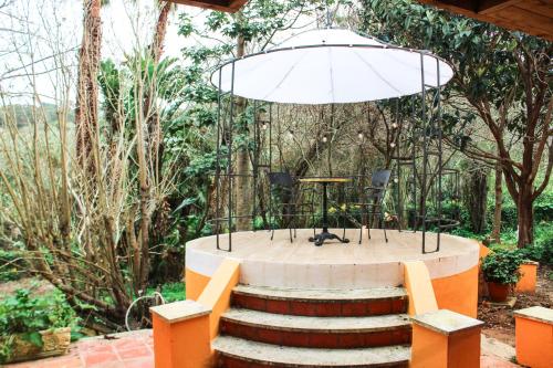 a patio with a table and stairs in a garden at Penedo Escape Nature in Colares