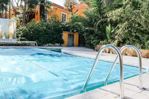 a swimming pool with two metal rails next to a house at Penedo Escape Nature in Colares