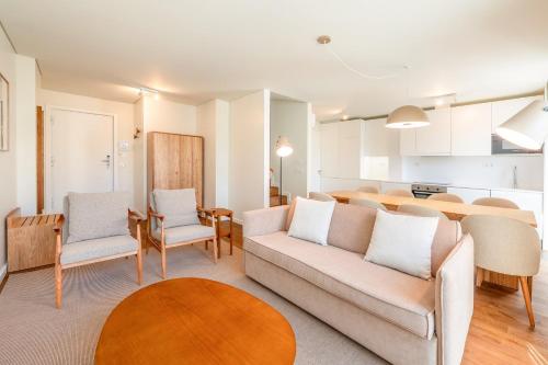 Una sala de estar con un sofá y sillas y una cocina. en GuestReady - Elias Garcia Apartments, en Lisboa