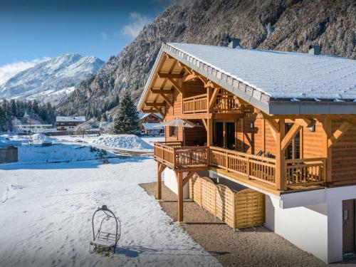 a log cabin in the mountains with snow on the ground at Chalet Les Vardafes - OVO Network in La Chapelle-dʼAbondance