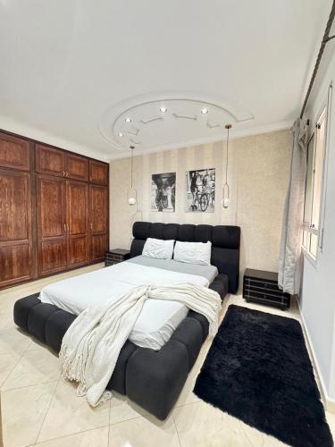 a large bedroom with a large bed with a large couch at Apartment oasis moderne in Tangier