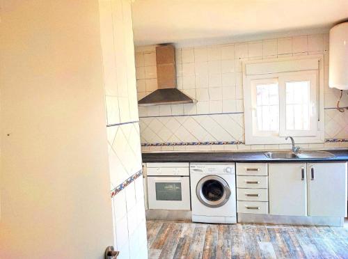 una cocina con lavadora y fregadero en Casa natural 1, en Chiclana de la Frontera