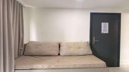 a couch sitting in a room next to a door at Flat pé na areia na praia de Porto de Galinhas próximo as piscinas naturais. in Porto De Galinhas
