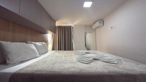 a bedroom with a bed with a shirt on it at Flat pé na areia na praia de Porto de Galinhas próximo as piscinas naturais. in Porto De Galinhas