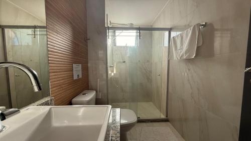 a bathroom with a shower and a toilet and a sink at Flat pé na areia na praia de Porto de Galinhas próximo as piscinas naturais. in Porto De Galinhas