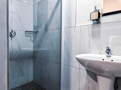 a white bathroom with a sink and a shower at Luxurious 2 bedroom Apartment! in Centurion