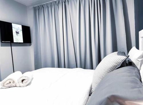 a bedroom with a white bed and a television at Luxurious 2 bedroom Apartment! in Centurion