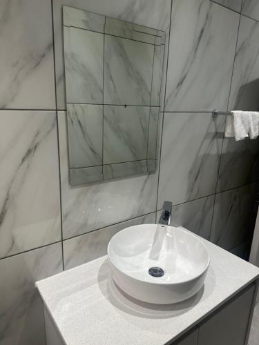 温特和克Little Haven Conerstone cottage的浴室里有白色洗手池和镜子