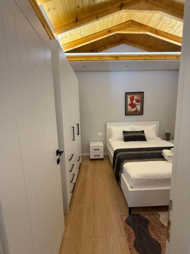 a bedroom with two beds and a wooden ceiling at Villa REJA Hamallaj in Draçi