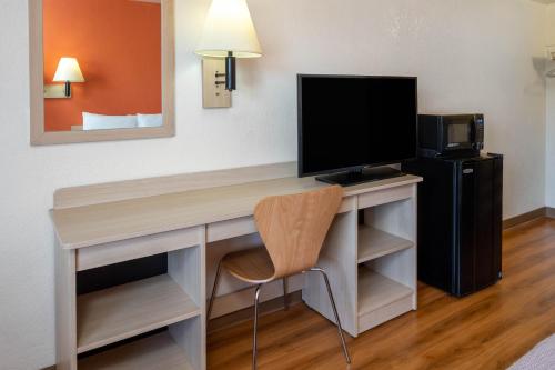 a desk with a television and a chair in a room at Jurupa Valley, CA - Riverside West 