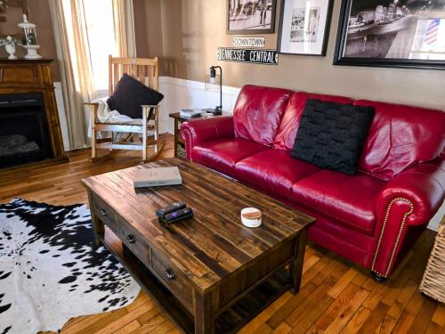 a living room with a red couch and a coffee table at Near Murphy River Walk Historic Downtown Home! in Murphy