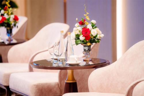 a table with glasses and a vase of flowers on it at Radisson Blu Ha Long Bay in Ha Long