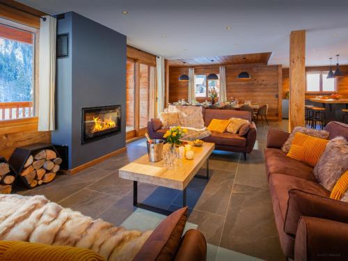 ein Wohnzimmer mit Sofas und einem Kamin in der Unterkunft Chalet Angelia - OVO Network in Le Grand-Bornand