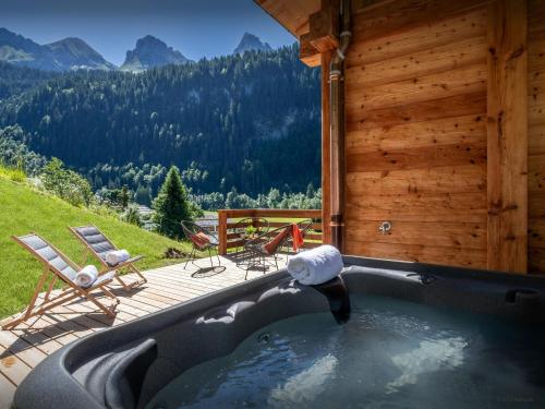 einen Whirlpool auf dem Deck einer Hütte in der Unterkunft Chalet Angelia - OVO Network in Le Grand-Bornand