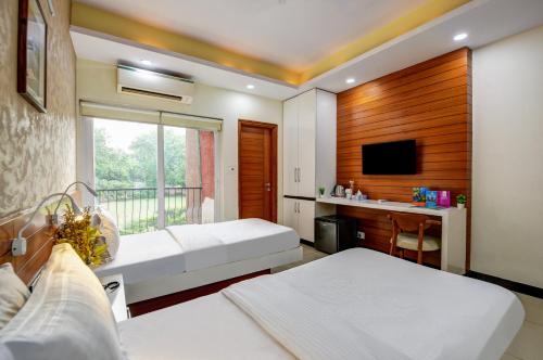 Una habitación de hotel con dos camas y un televisor. en National YMCA Hostel, en Nueva Delhi