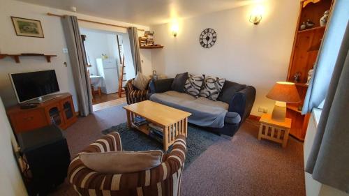 a living room with a couch and a table at Rhumhor in Bunessan