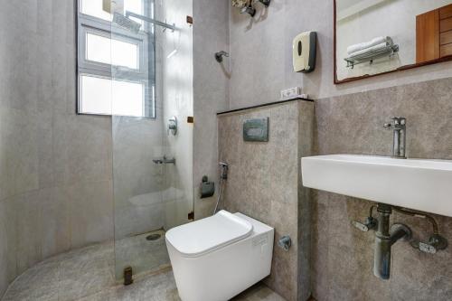a bathroom with a toilet and a sink and a shower at National YMCA Hostel in New Delhi
