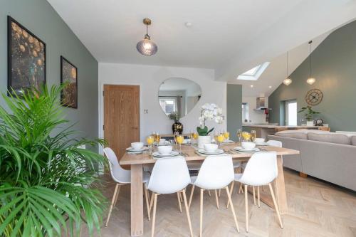 a dining room with a table and white chairs at Comfortable & Contemporary 5-Bed 3 Bathroom Home in Gloucestershire